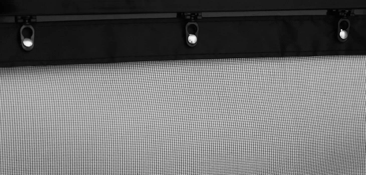 The top edge of a FEGO sliding garage door screen with three roller clips on its track