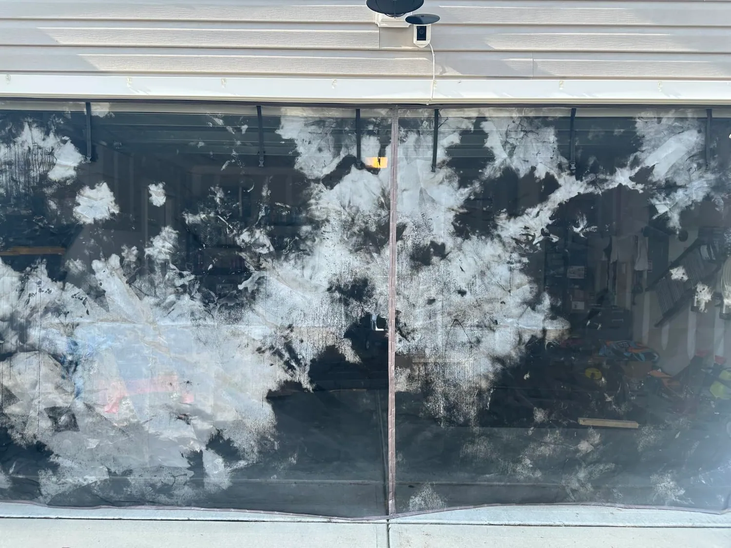 Buyer photo: a FEGO privacy garage door screen with its silver coating worn away in patches