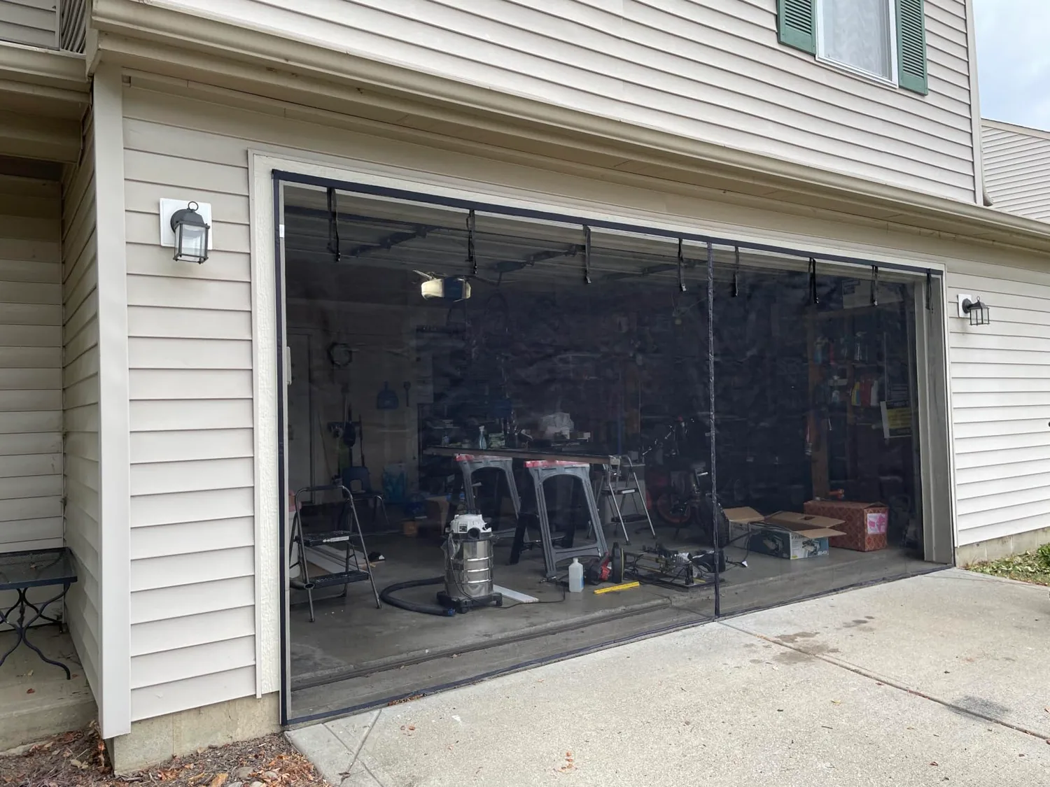 Buyer photo: a black FEGO garage door screen closed across a two-car garage